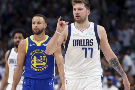 Dallas Mavericks guard Luka Doncic, right, and Golden State Warriors guard Stephen Curry, left, look to the sidelines during a break in play Tuesday, May 24, 2022, in Dallas.