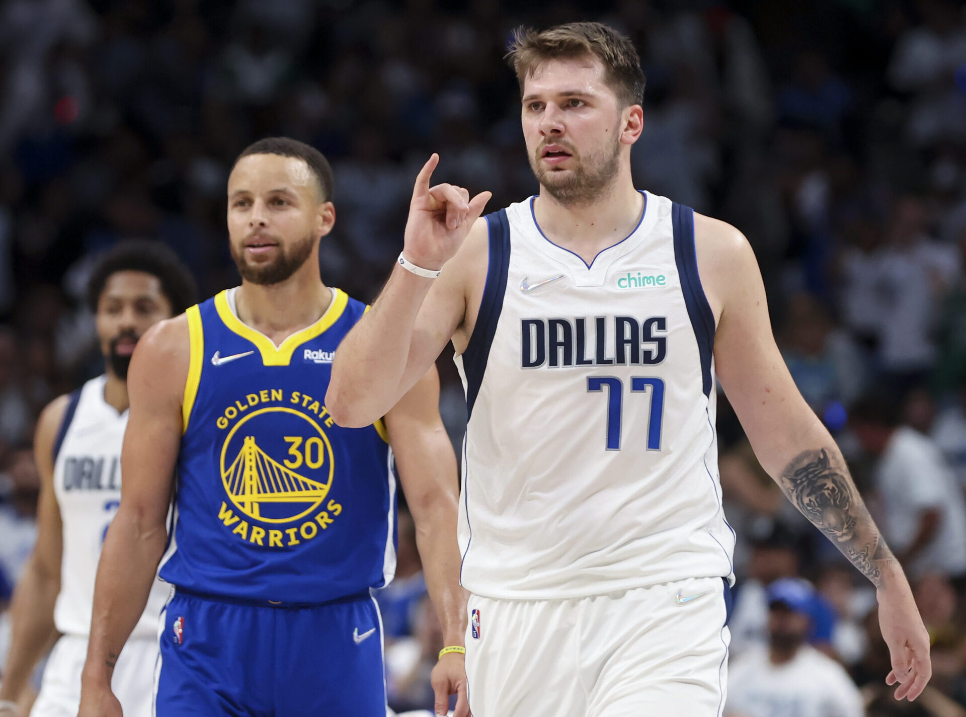 Dallas Mavericks guard Luka Doncic, right, and Golden State Warriors guard Stephen Curry, left, look to the sidelines during a break in play Tuesday, May 24, 2022, in Dallas.