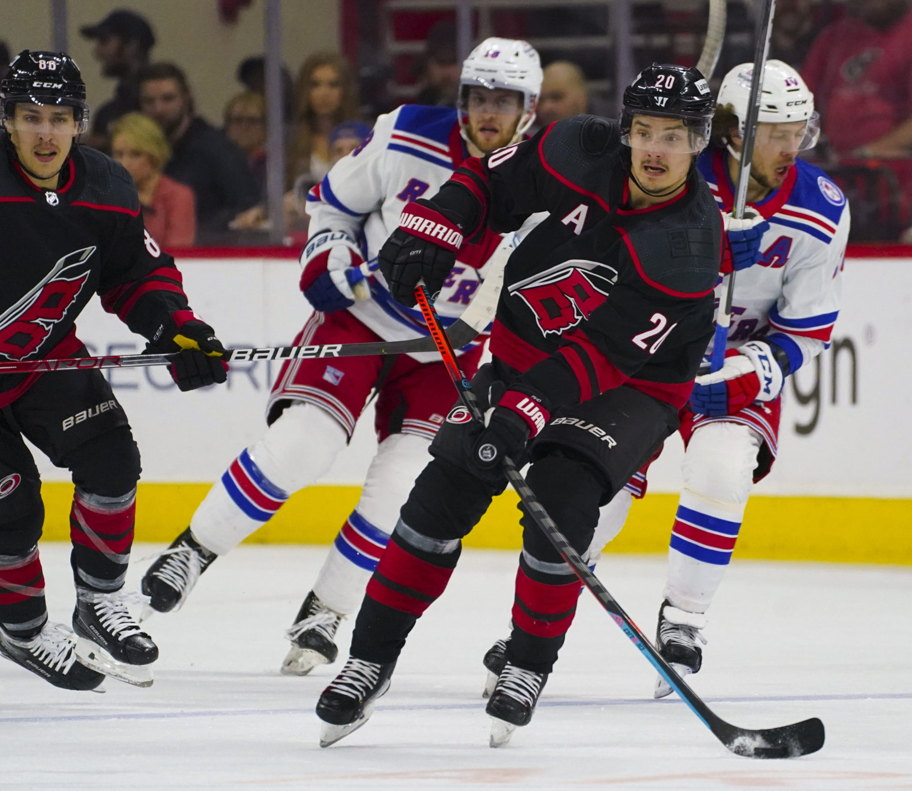 Carolina Hurricanes center Sebastian Aho (center) skates with the puck against the New York Rangers in Game 5 of the second round of the 2022 Stanley Cup Playoffs