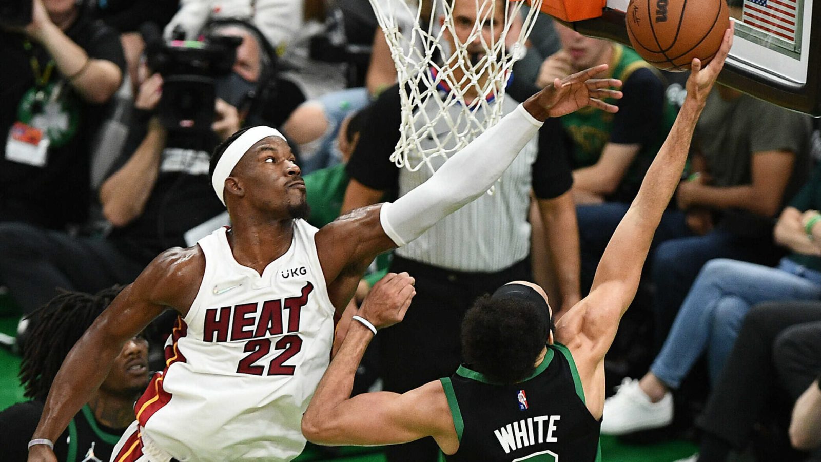 Miami Heat forward Jimmy Butler, left, leaps to contest a layup by Boston Celtics guard Derrick White, right, with back to camera, on Friday, May 27, 2022, in Boston.