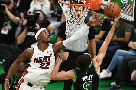 Miami Heat forward Jimmy Butler, left, leaps to contest a layup by Boston Celtics guard Derrick White, right, with back to camera, on Friday, May 27, 2022, in Boston.