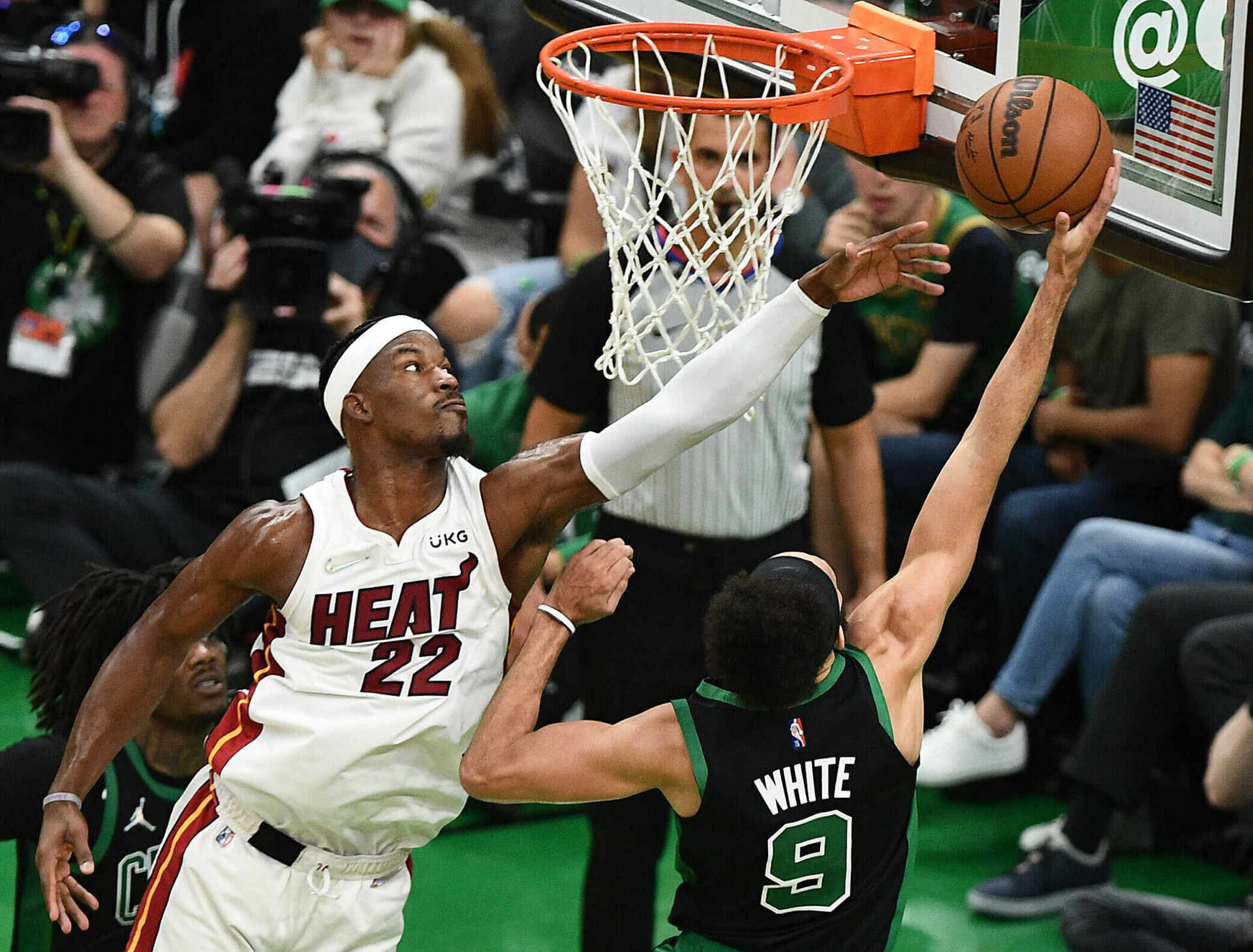 Miami Heat forward Jimmy Butler, left, leaps to contest a layup by Boston Celtics guard Derrick White, right, with back to camera, on Friday, May 27, 2022, in Boston.