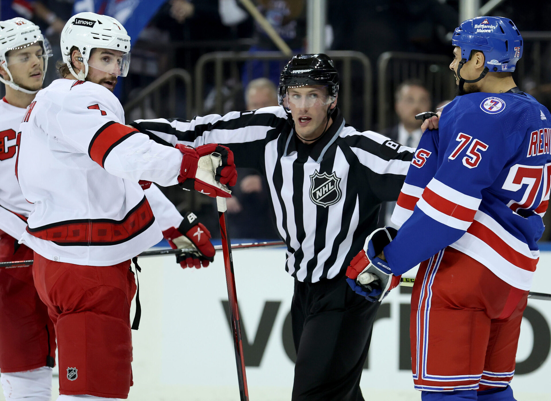 Carolina Hurricanes defenseman Brendan Smith (left) and New York Rangers right wing Ryan Reaves (right) are separated by linesman Ryan Daisy (81) during Game 6 of the second round of the 2022 Stanley Cup Playoffs