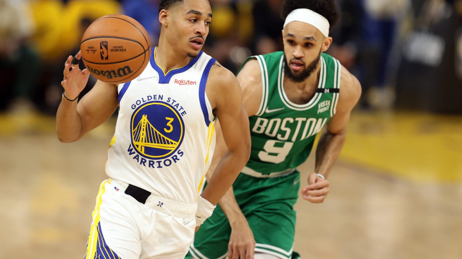 Golden State Warriors guard Jordan Poole (left) dribbles the basketball with his right hand as Boston Celtics guard Derrick White (right) pursues from behind during Game 1 of the 2022 NBA Finals