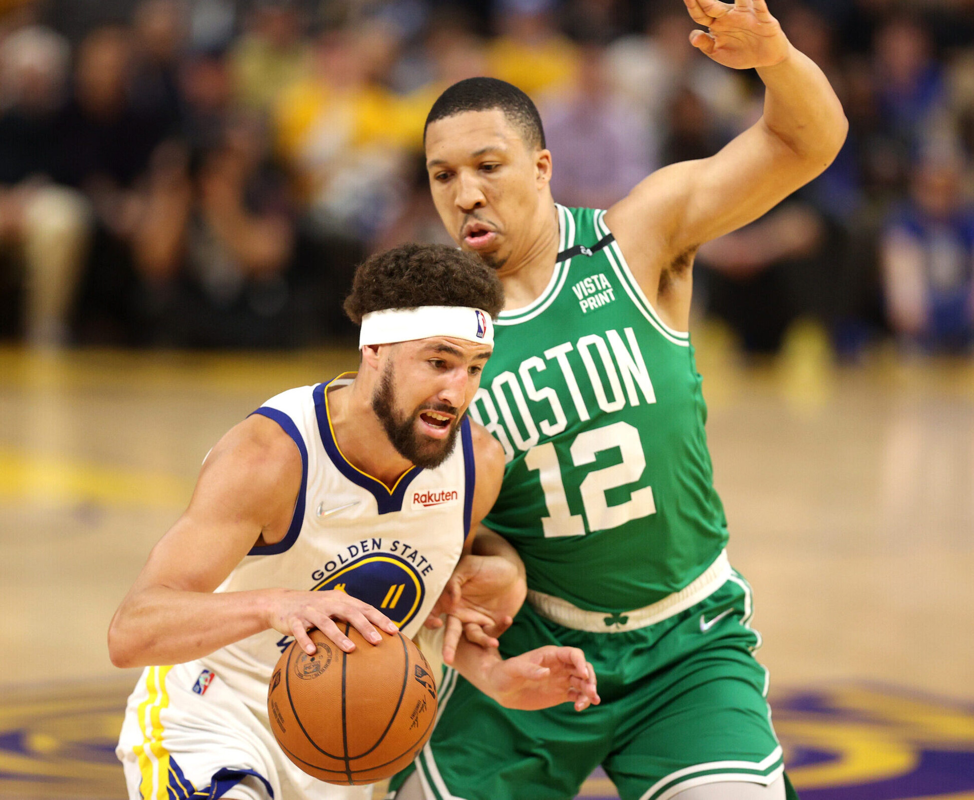 Golden State Warriors guard Klay Thompson (left) dribbles the baseball with his right hand and tries to get around Boston Celtics defender Grant Williams during Game 1 of the 2022 NBA Finals