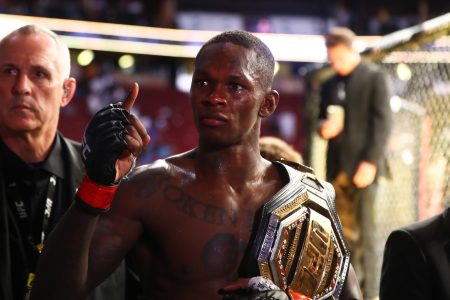 Israel Adesanya celebrates with the championship belt during UFC 263