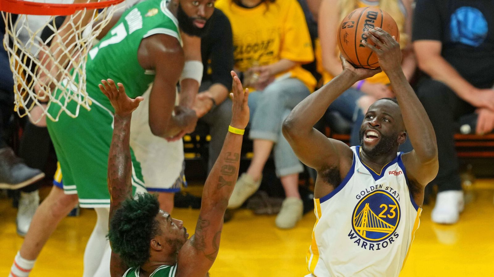 Golden State Warriors forward Draymond Green, right, shoots over the outstretched arms of Boston Celtics guard Marcus Smart, left, on June 2, 2022, in San Francisco.