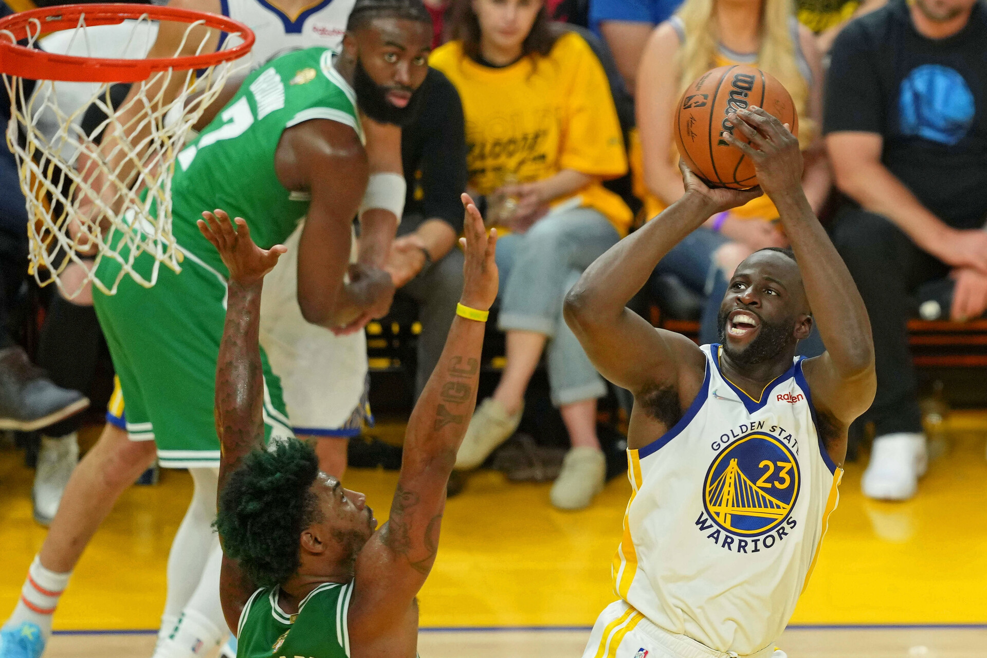 Golden State Warriors forward Draymond Green, right, shoots over the outstretched arms of Boston Celtics guard Marcus Smart, left, on June 2, 2022, in San Francisco.