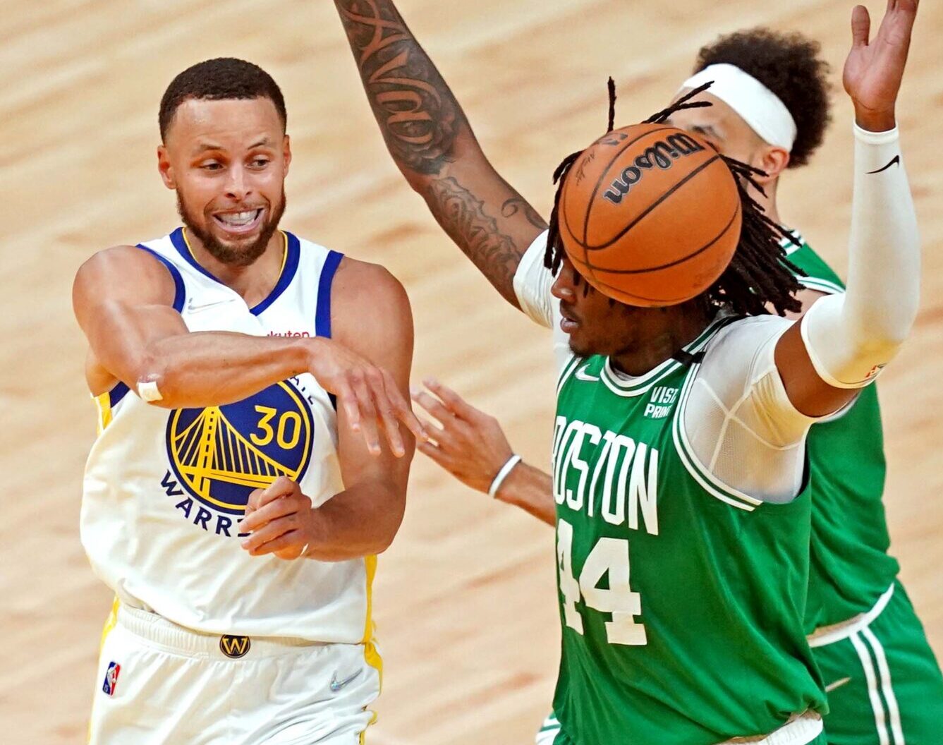 Golden State Warriors guard Stephen Curry, left, passes the ball against Boston Celtics center Robert Williams III, right, in game one of the 2022 NBA Finals at Chase Center on June 2, 2022.