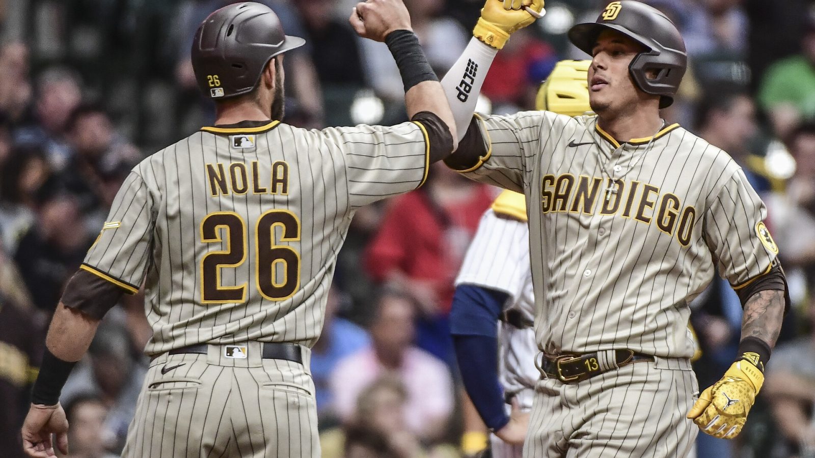 San Diego Padres third baseman Manny Machado (right) gives teammate and catcher Austin Nola (left) a forearm bash after hitting a 3-run home run against the Milwaukee Brewers