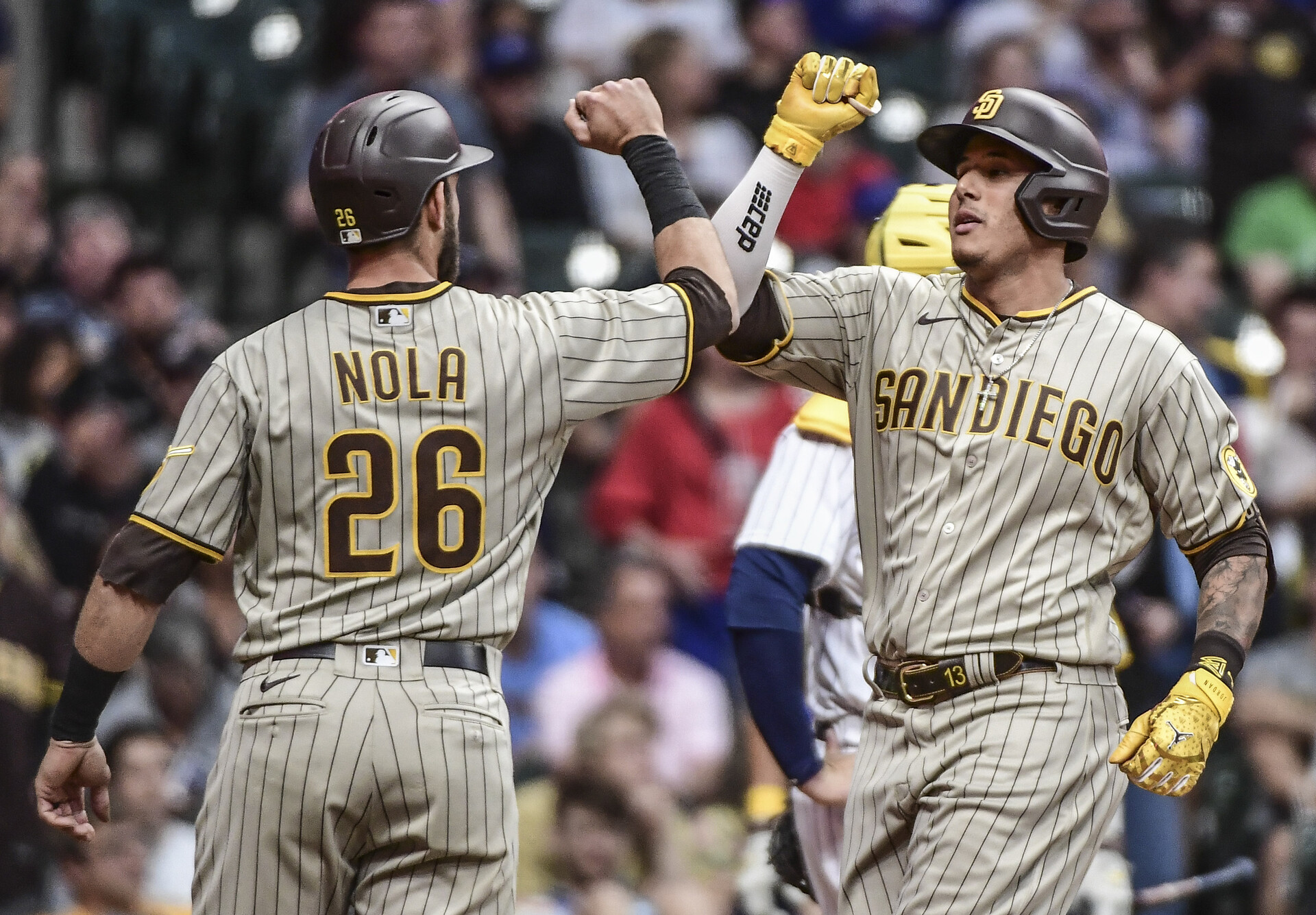 San Diego Padres third baseman Manny Machado (right) gives teammate and catcher Austin Nola (left) a forearm bash after hitting a 3-run home run against the Milwaukee Brewers