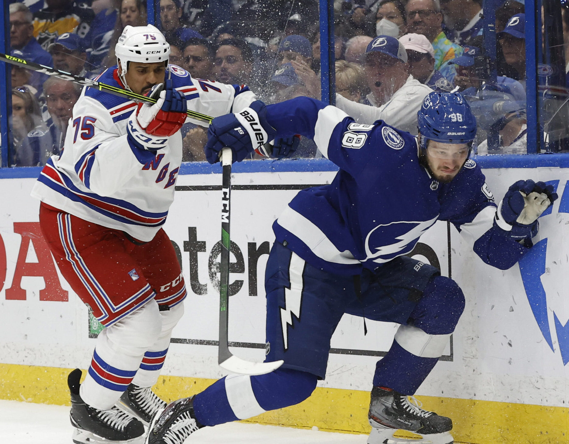 New York Rangers right wing Ryan Reaves (left) checks Tampa Bay Lightning defenseman Mikhail Sergachev (right) into the boards during the Eastern Conference Final of the 2022 Stanley Cup Playoffs