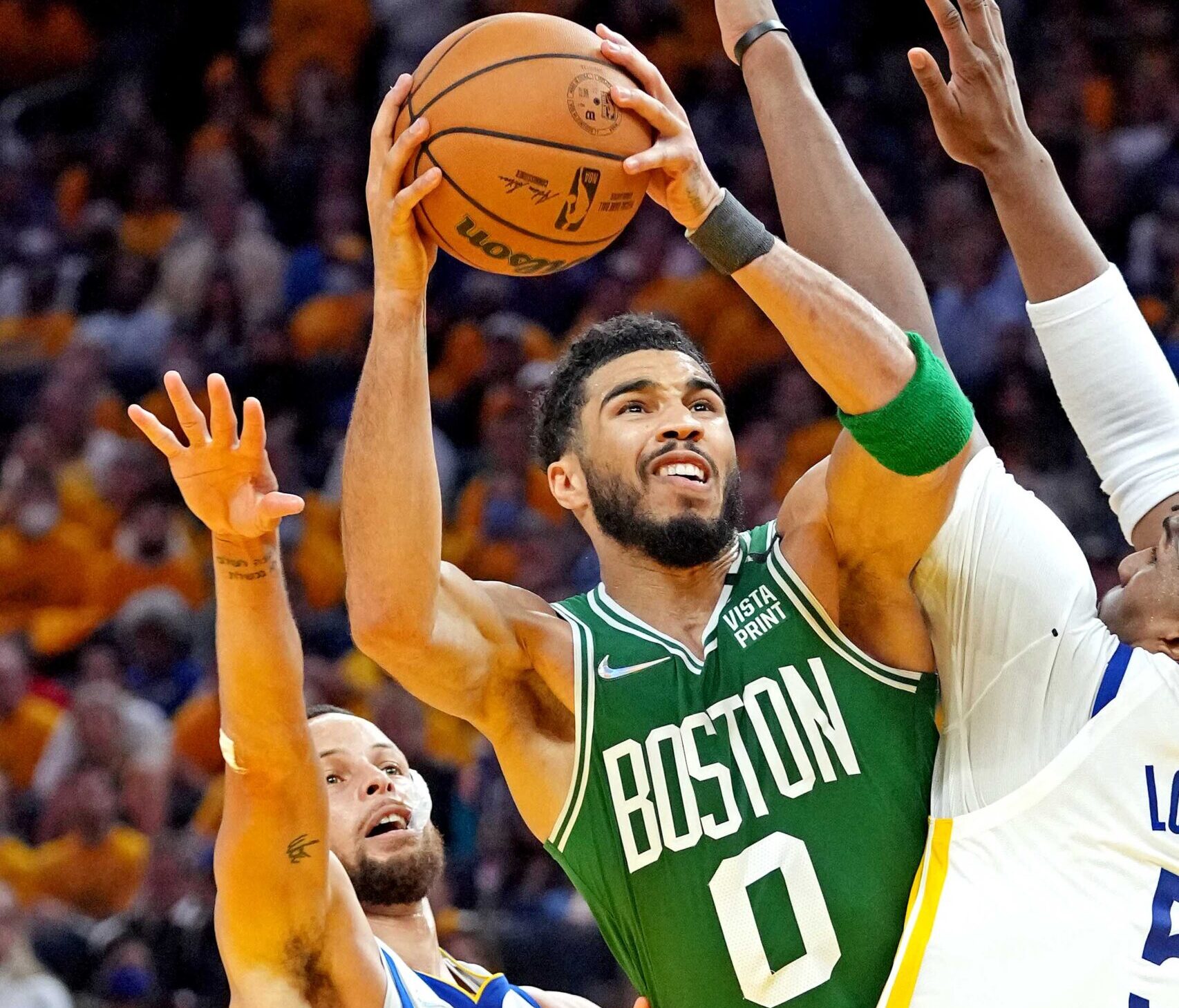 Boston Celtics forward Jayson Tatum, middle, shoots the ball against Golden State Warriors' Stephen Curry, left, and Kevon Looney, right, during the third quarter during game two of the 2022 NBA Finals at Chase Center on June 5, 2022.