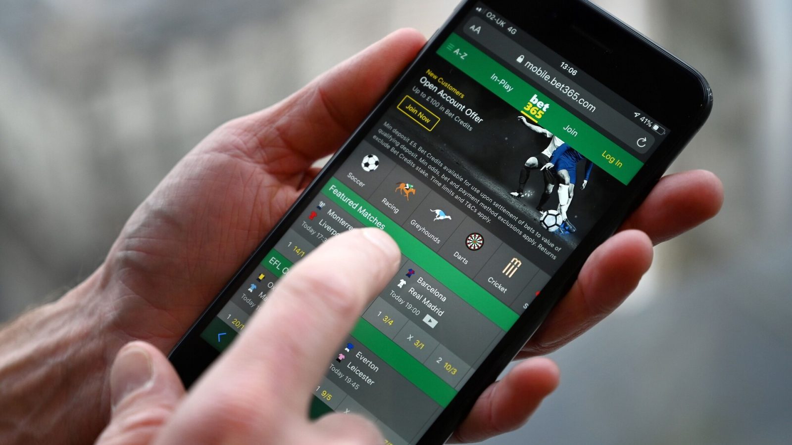 A man poses for a photograph with the online gambling website Bet365 displayed on a smartphone, in London on December 18, 2019. - Denise Coates, chief executive of British online betting giant Bet365, has retained her place as Britain's highest-paid boss, according to the group's annual report published on Wednesday. She was paid a basic salary of £277 million ($366 million, 328 million euros) in the group's financial year to March, the company's annual report showed.