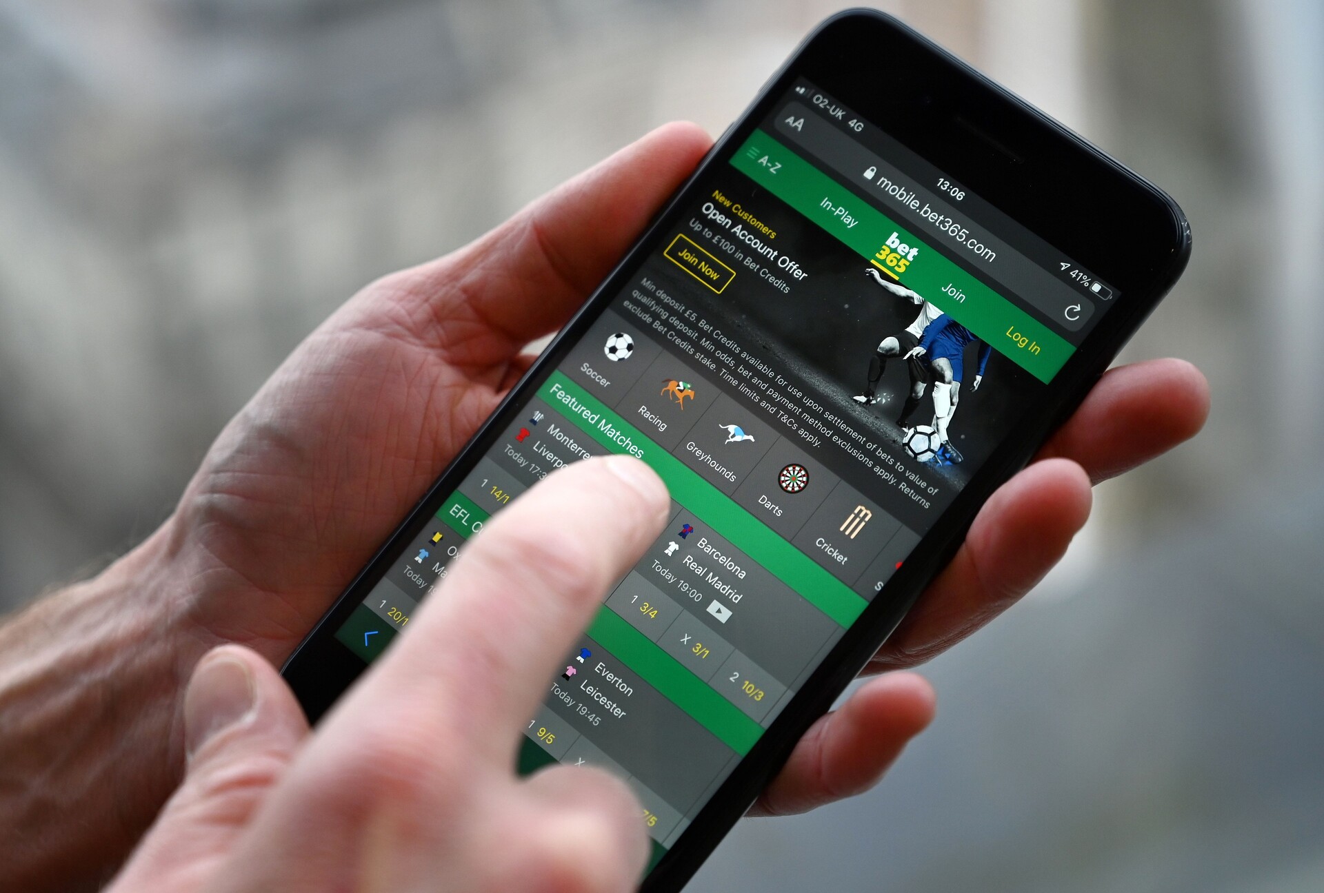 A man poses for a photograph with the online gambling website Bet365 displayed on a smartphone, in London on December 18, 2019. - Denise Coates, chief executive of British online betting giant Bet365, has retained her place as Britain's highest-paid boss, according to the group's annual report published on Wednesday. She was paid a basic salary of £277 million ($366 million, 328 million euros) in the group's financial year to March, the company's annual report showed.