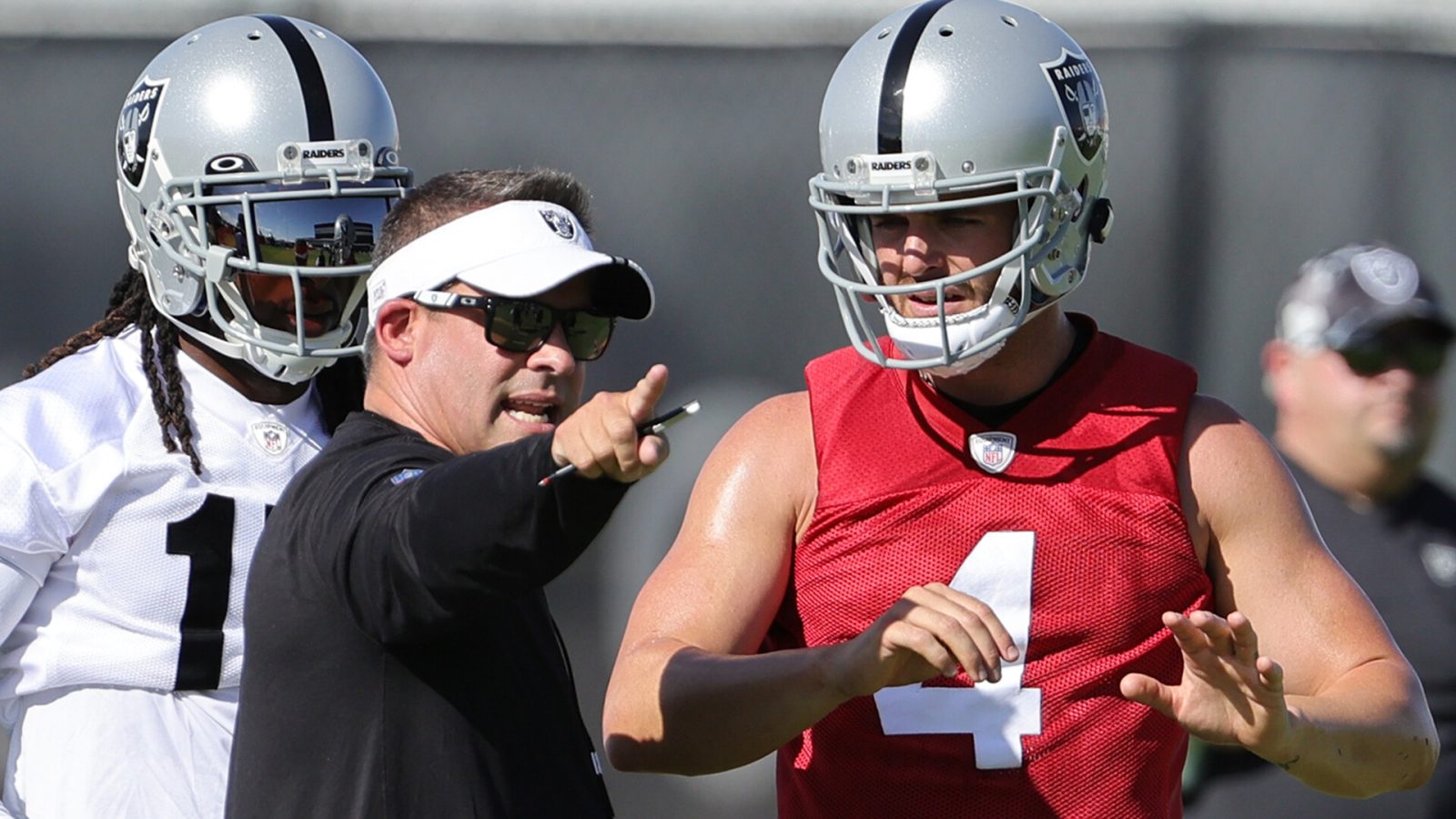 Wide receiver Davante Adams #17, head coach Josh McDaniels and quarterback Derek Carr #4 of the Las Vegas Raiders talk during training camp at the Las Vegas Raiders Headquarters/Intermountain Healthcare Performance Center on July 24, 2022 in Henderson, Nevada.