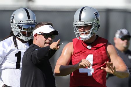 Wide receiver Davante Adams #17, head coach Josh McDaniels and quarterback Derek Carr #4 of the Las Vegas Raiders talk during training camp at the Las Vegas Raiders Headquarters/Intermountain Healthcare Performance Center on July 24, 2022 in Henderson, Nevada.