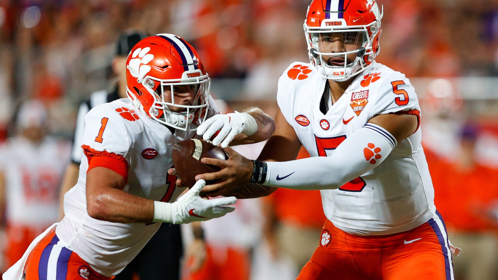 Clemson Tigers quarterback D.J. Uiagalelei (5) hands the ball off to running back Will Shipley (1) in the first half against the Iowa State Cyclones at Camping World Stadium