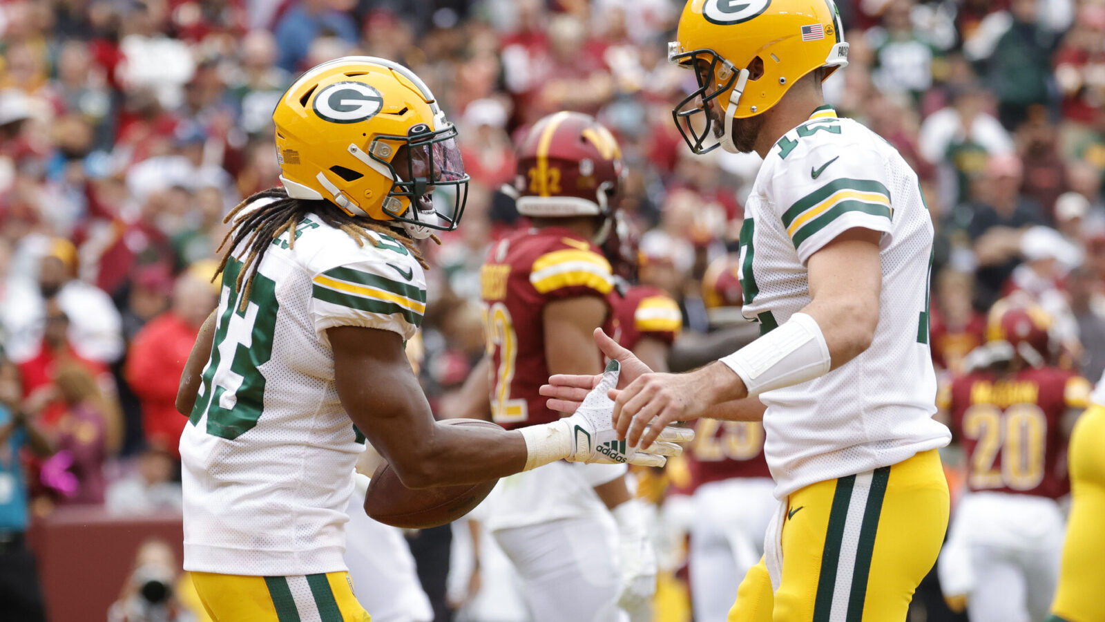 Oct 23, 2022; Landover, Maryland, USA; Green Bay Packers running back Aaron Jones (33) /celebrates with Packers quarterback Aaron Rodgers (12) after scoring a touchdown against the Washington Commanders during the first quarter at FedExField.