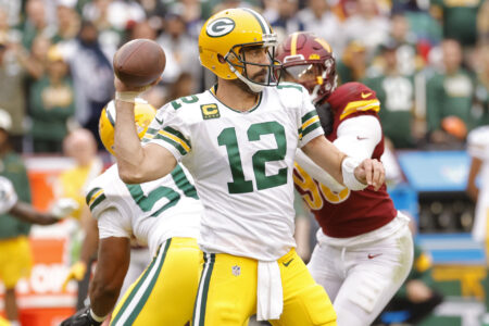 Oct 23, 2022; Landover, Maryland, USA; Green Bay Packers quarterback Aaron Rodgers (12) passes the ball as Washington Commanders defensive end Montez Sweat (90) chases during the fourth quarter at FedExField.