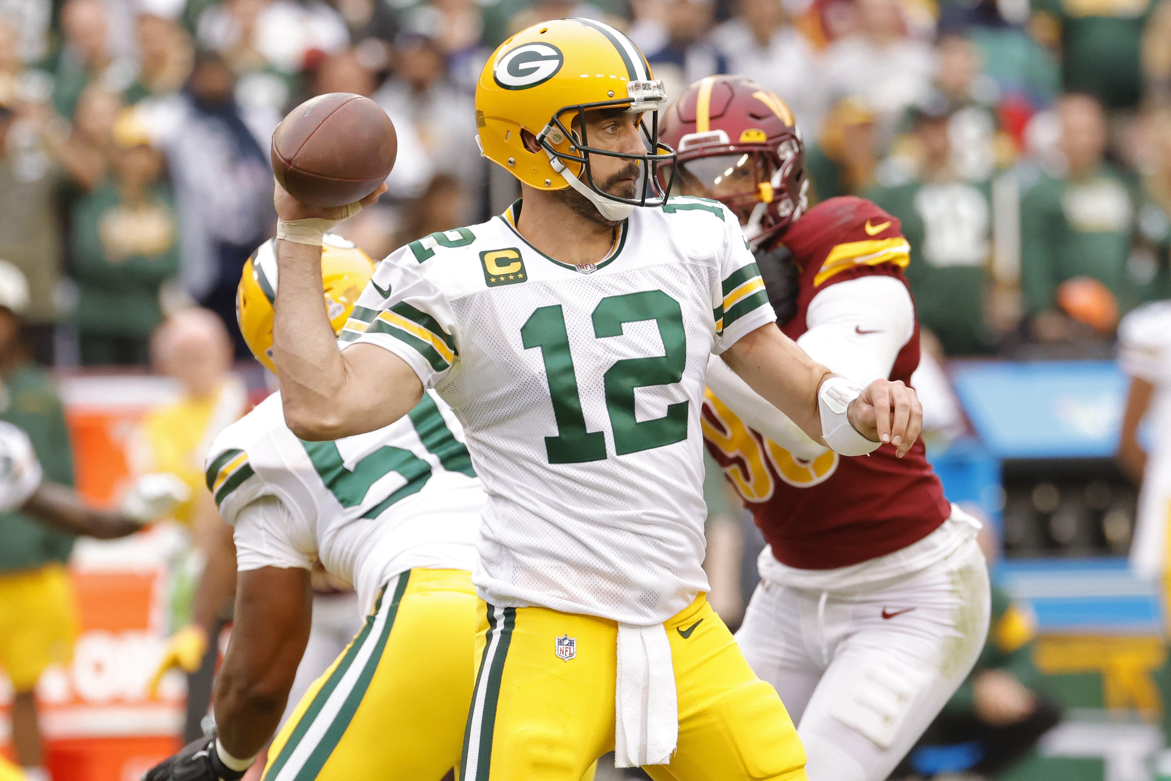 Oct 23, 2022; Landover, Maryland, USA; Green Bay Packers quarterback Aaron Rodgers (12) passes the ball as Washington Commanders defensive end Montez Sweat (90) chases during the fourth quarter at FedExField.