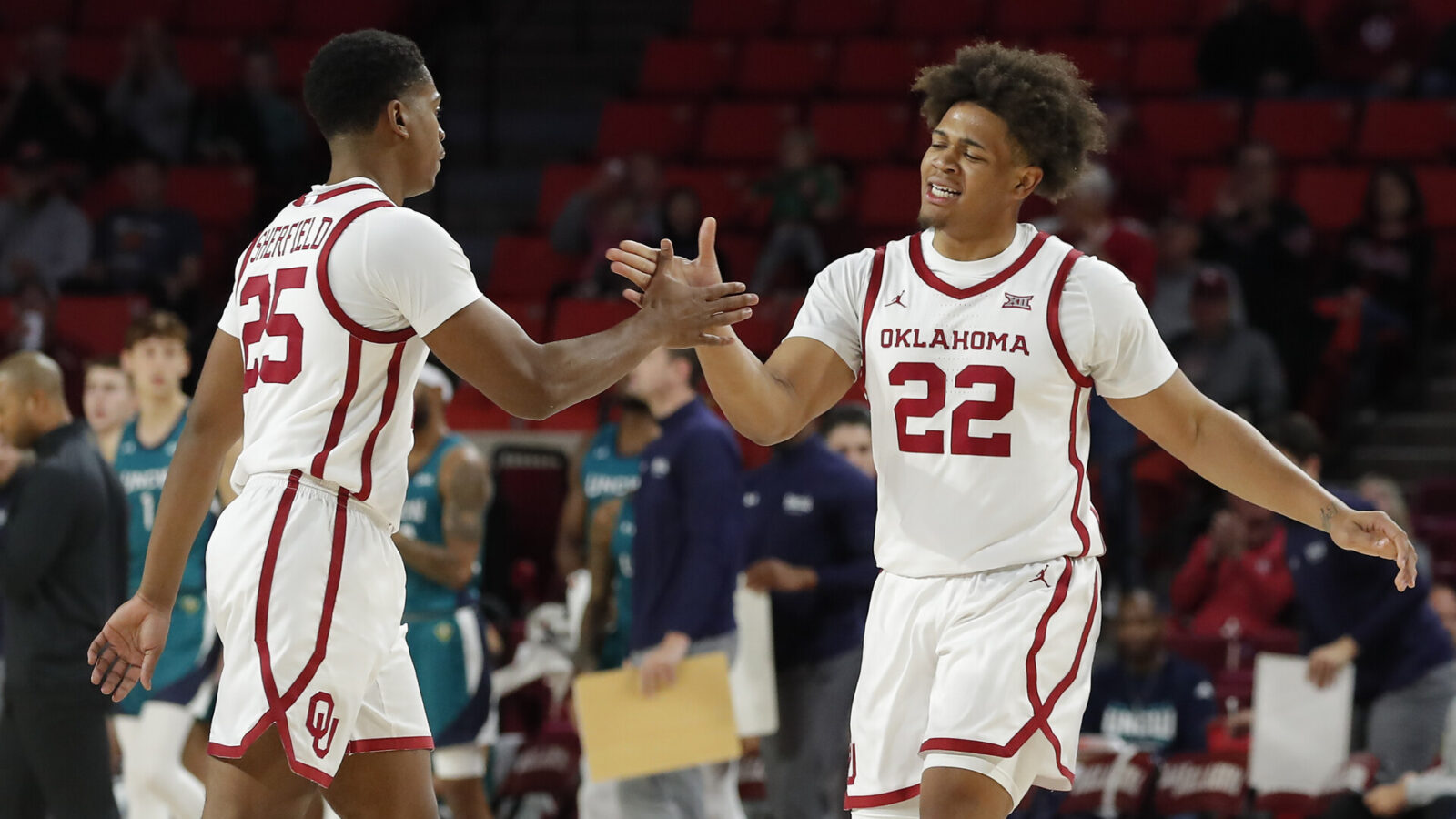 Oklahoma guard C.J. Noland (22) celebrates with Oklahoma guard Grant Sherfield (25) following a basket against NC Wilmington during the first half at Lloyd Noble Center.