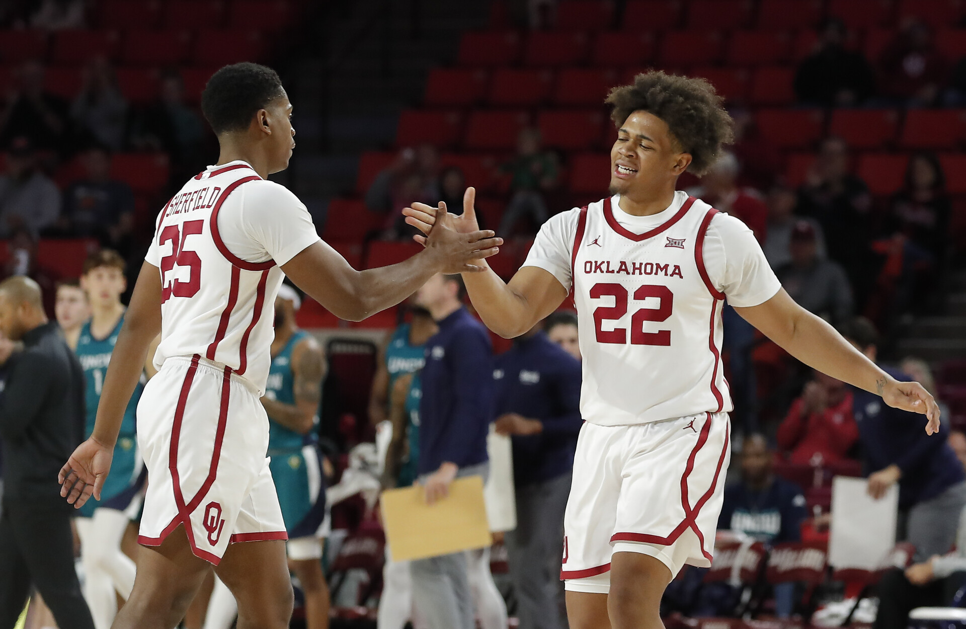 Oklahoma guard C.J. Noland (22) celebrates with Oklahoma guard Grant Sherfield (25) following a basket against NC Wilmington during the first half at Lloyd Noble Center.