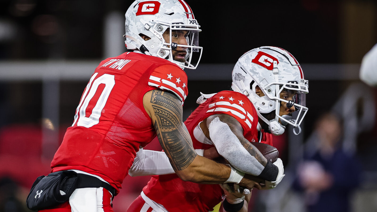 Jordan Ta'amu #10 of the DC Defenders hands the ball off to Abram Smith #4 during the first half of the XFL game against the Seattle Sea Dragons at Audi Field on February 19, 2023 in Washington, DC.