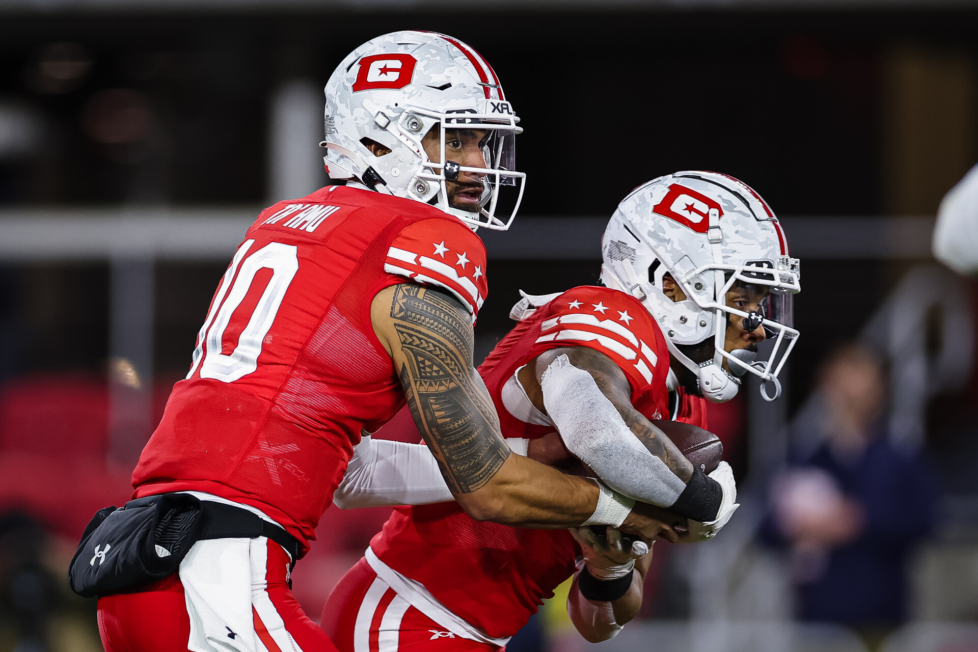 Jordan Ta'amu #10 of the DC Defenders hands the ball off to Abram Smith #4 during the first half of the XFL game against the Seattle Sea Dragons at Audi Field on February 19, 2023 in Washington, DC.