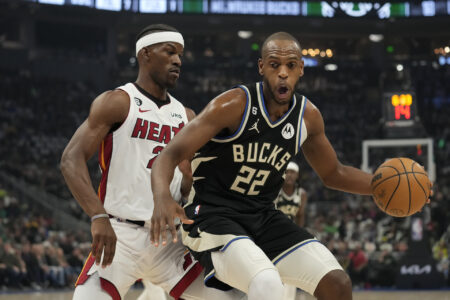 Khris Middleton #22 of the Milwaukee Bucks dribbles the ball against Jimmy Butler #22 of the Miami Heat during the first half of Game Two of the Eastern Conference First Round Playoffs at Fiserv Forum on April 19, 2023 in Milwaukee, Wisconsin.