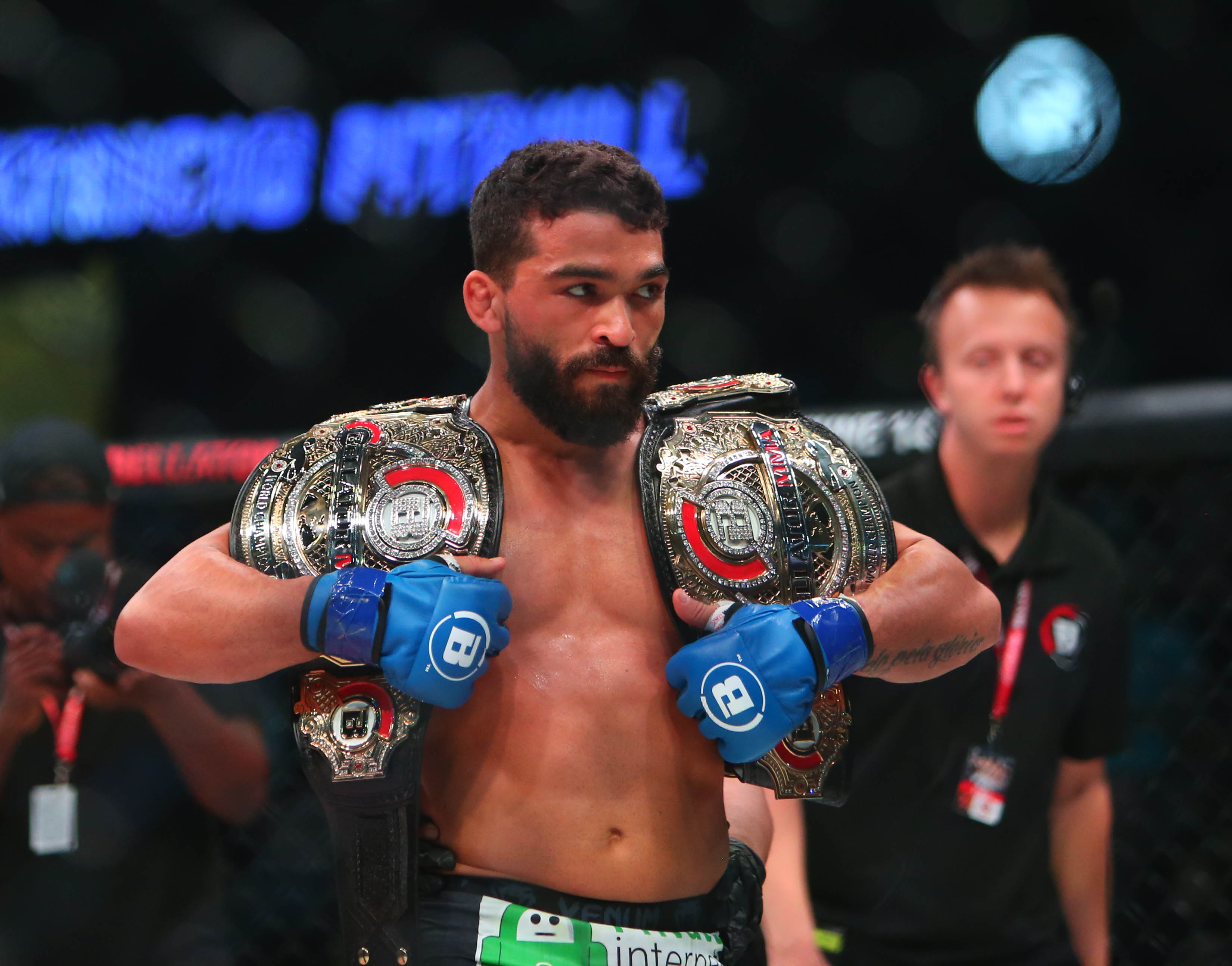 Patricio Freire (blue gloves) celebrates with his championship belts after defeating Michael Chandler (red gloves) during Bellator 221 at Allstate Arena.