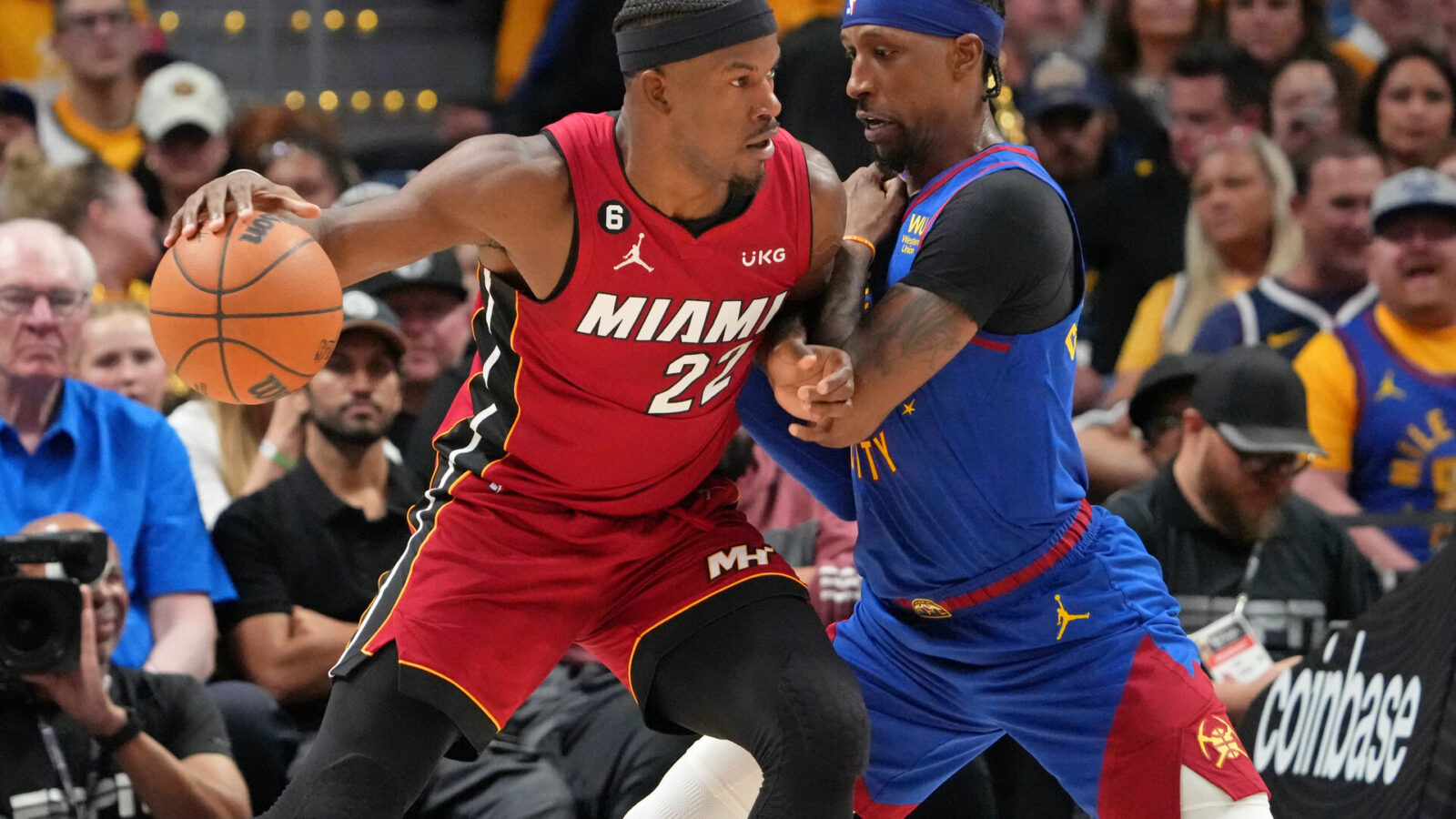 Miami Heat forward Jimmy Butler (22) dribbles the ball against Denver Nuggets guard Kentavious Caldwell-Pope (5) during the third quarter in game one of the 2023 NBA Finals at Ball Arena.