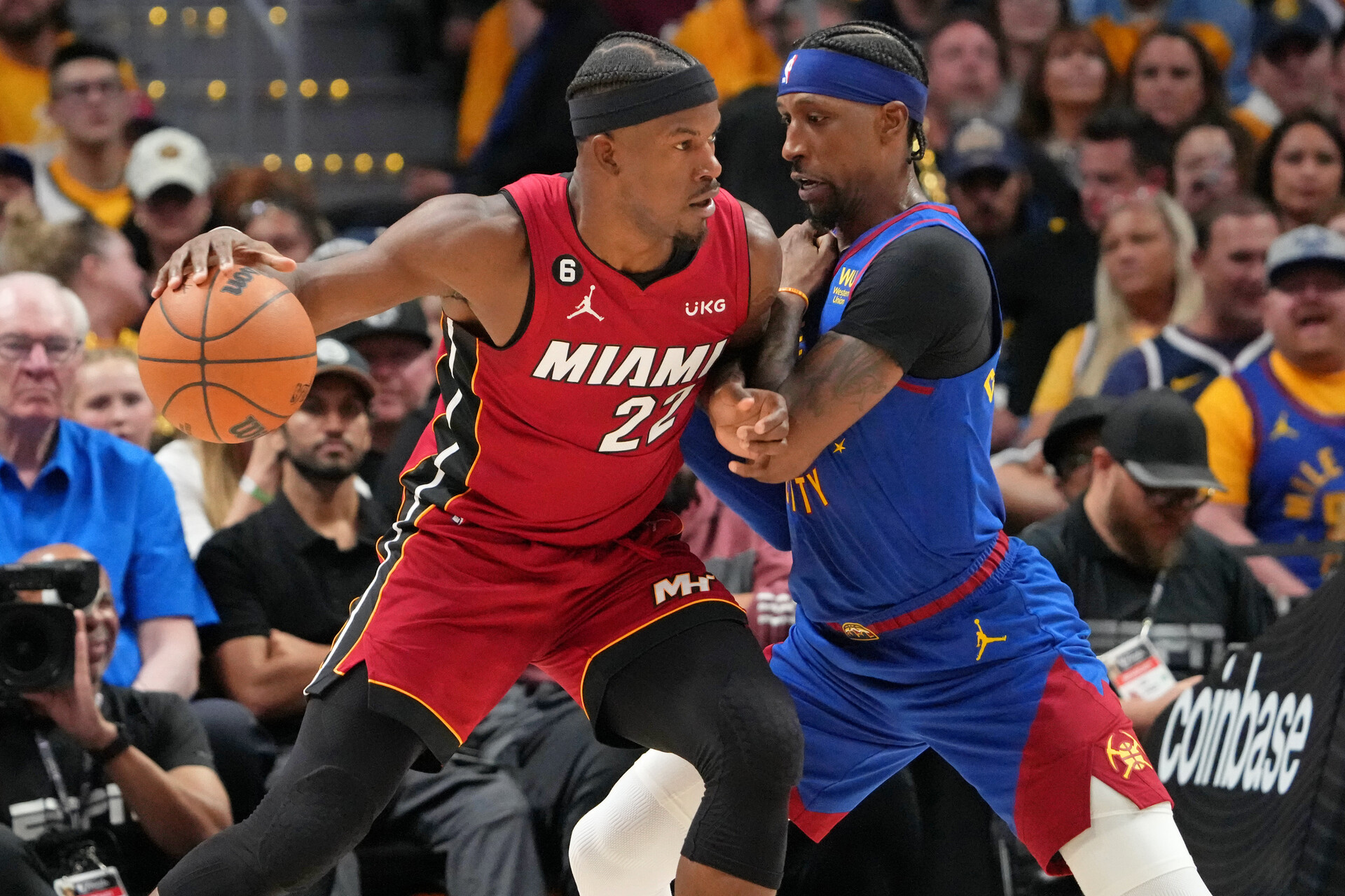 Miami Heat forward Jimmy Butler (22) dribbles the ball against Denver Nuggets guard Kentavious Caldwell-Pope (5) during the third quarter in game one of the 2023 NBA Finals at Ball Arena.