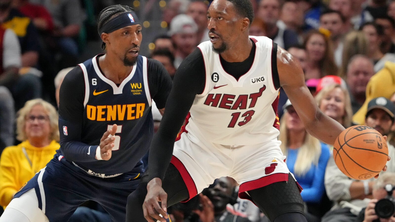 Miami Heat center Bam Adebayo (13) dribbles the ball against Denver Nuggets guard Kentavious Caldwell-Pope (5) during the second quarter in game two of the 2023 NBA Finals at Ball Arena.
