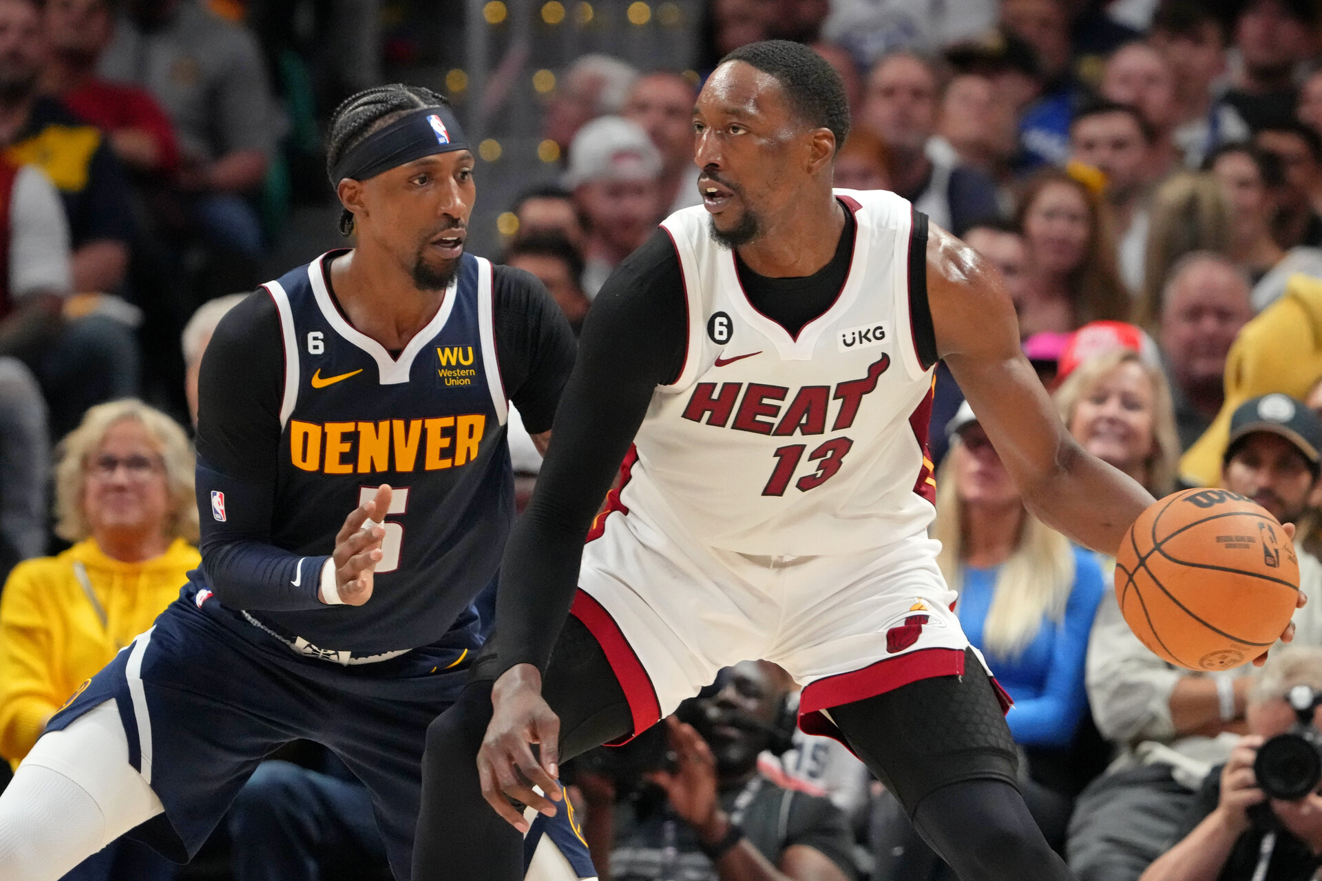 Miami Heat center Bam Adebayo (13) dribbles the ball against Denver Nuggets guard Kentavious Caldwell-Pope (5) during the second quarter in game two of the 2023 NBA Finals at Ball Arena.