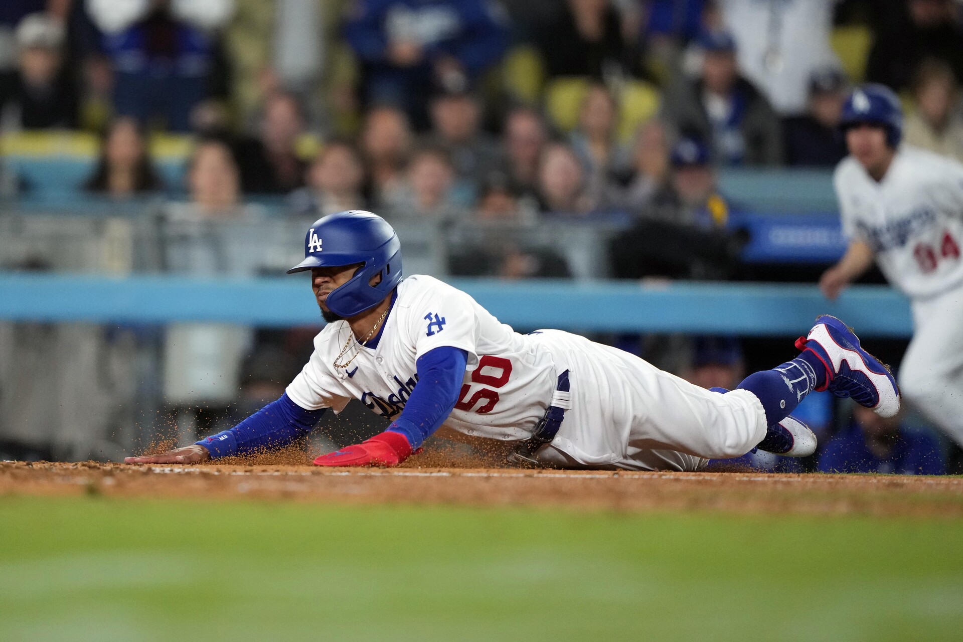 Jun 13, 2023; Los Angeles, California, USA; Los Angeles Dodgers shortstop Mookie Betts (50) slides into home plate in the seventh inning against the Chicago White Sox at Dodger Stadium.