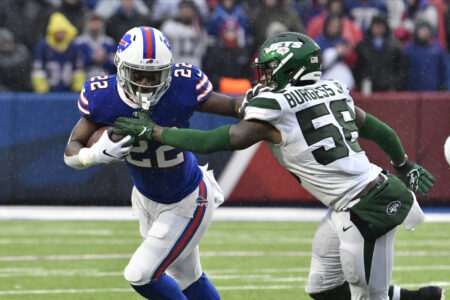 Buffalo Bills running back T.J. Yeldon (22) tries to outrun New York Jets outside linebacker James Burgess (58) in the third quarter at New Era Field.