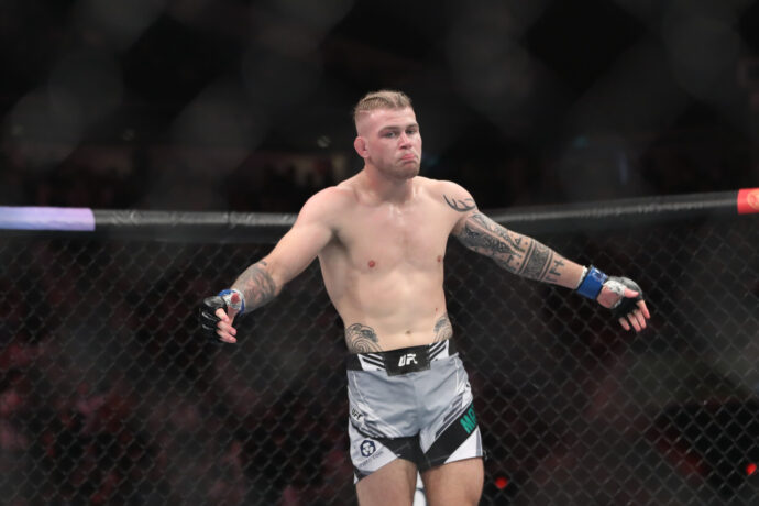 Jakes Matthews (blue gloves) reacts after the fight against Andre Fialho (red gloves) during UFC 275 at Singapore Indoor Stadium.