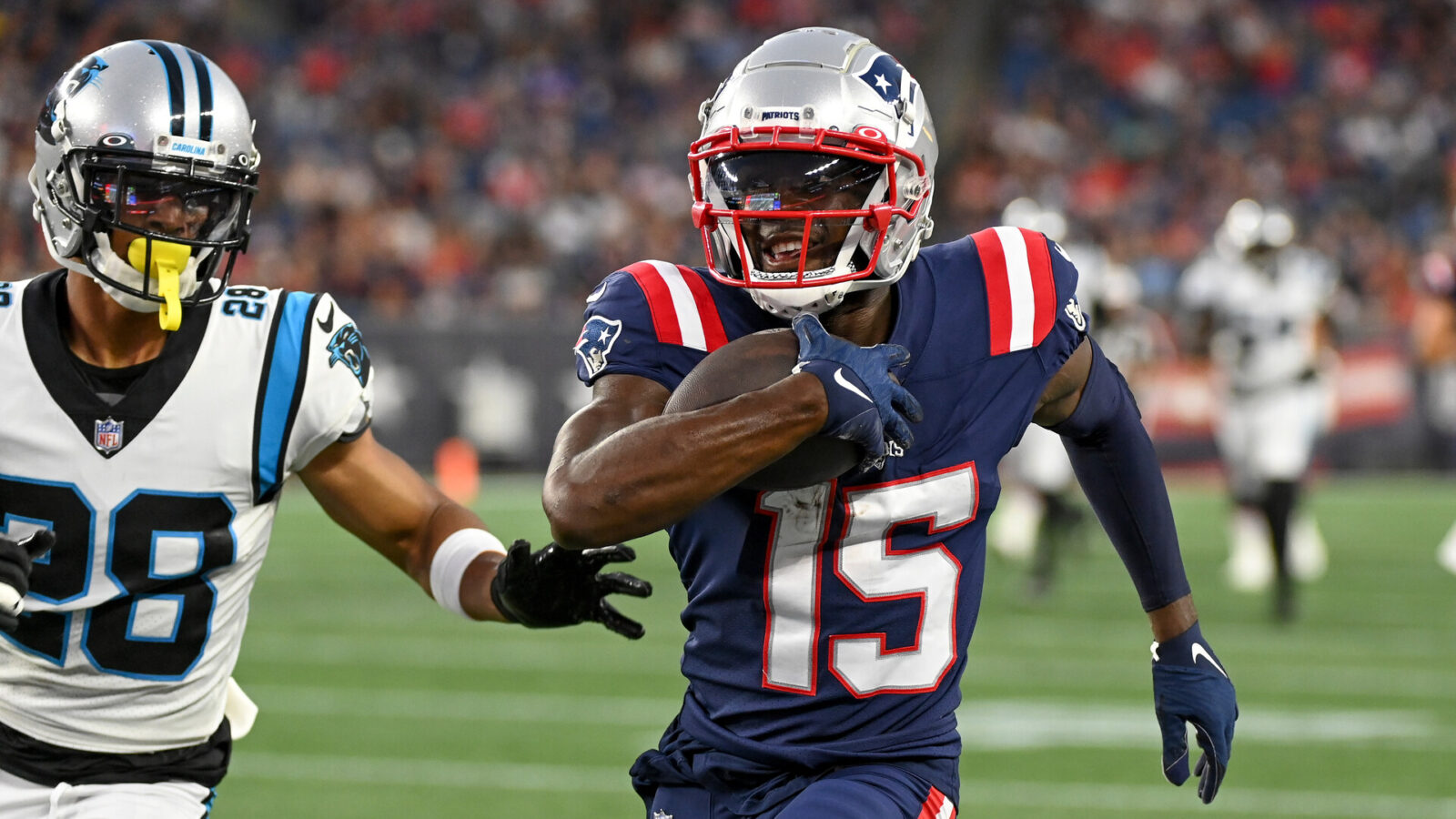 New England Patriots wide receiver Nelson Agholor (15) runs after making a catch with Carolina Panthers cornerback Keith Taylor Jr. (28) in pursuit during the first half of a preseason game at Gillette Stadium.