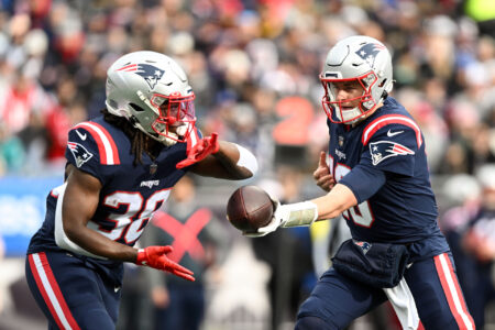 Jan 1, 2023; Foxborough, Massachusetts, USA; New England Patriots quarterback Mac Jones (10) hands the ball to running back Rhamondre Stevenson (38) during the first half of a game against the Miami Dolphins at Gillette Stadium.