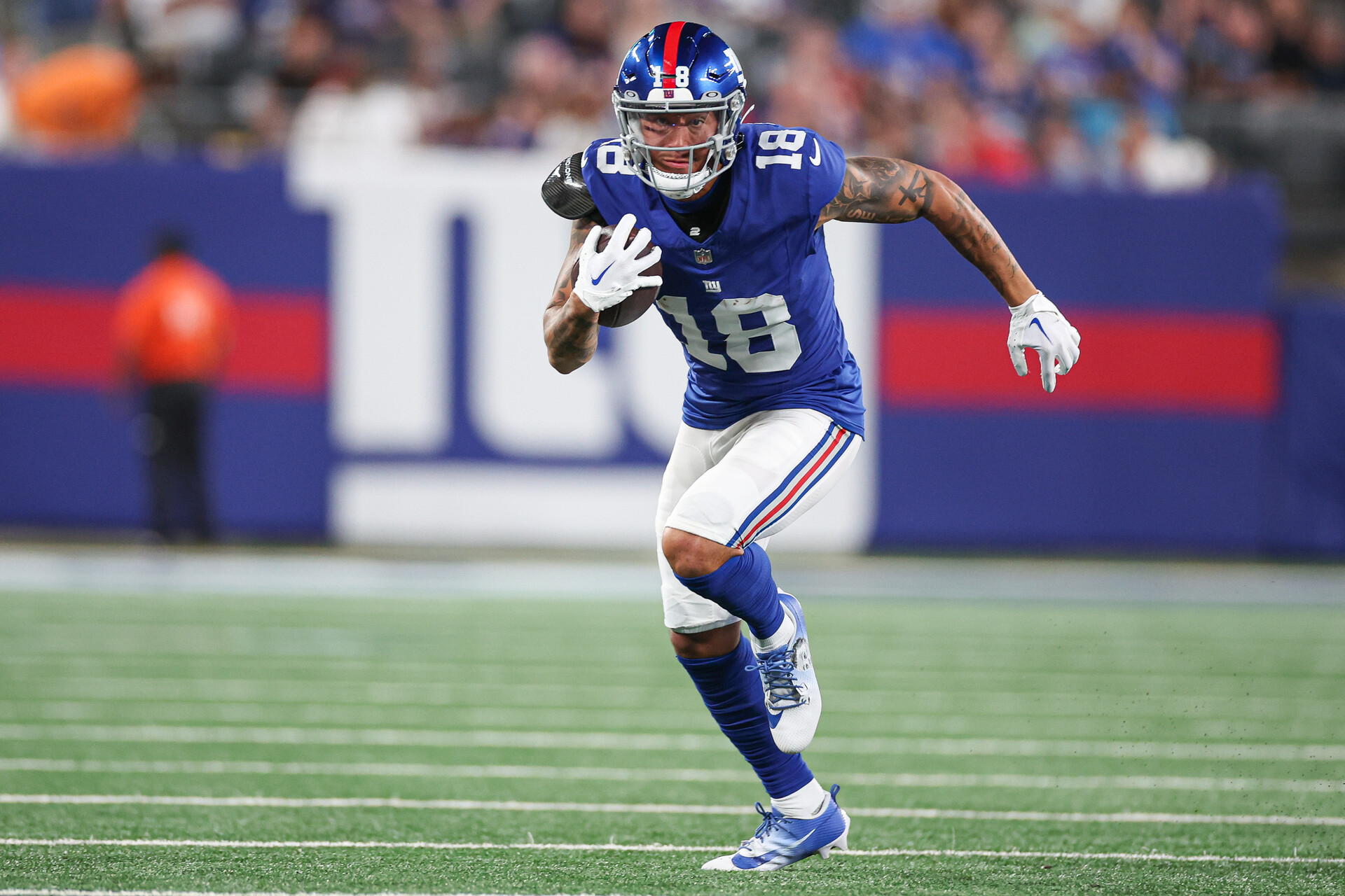 Aug 18, 2023; East Rutherford, New Jersey, USA; New York Giants wide receiver Isaiah Hodgins (18) gains yards after catch during the first half against the Carolina Panthers at MetLife Stadium.