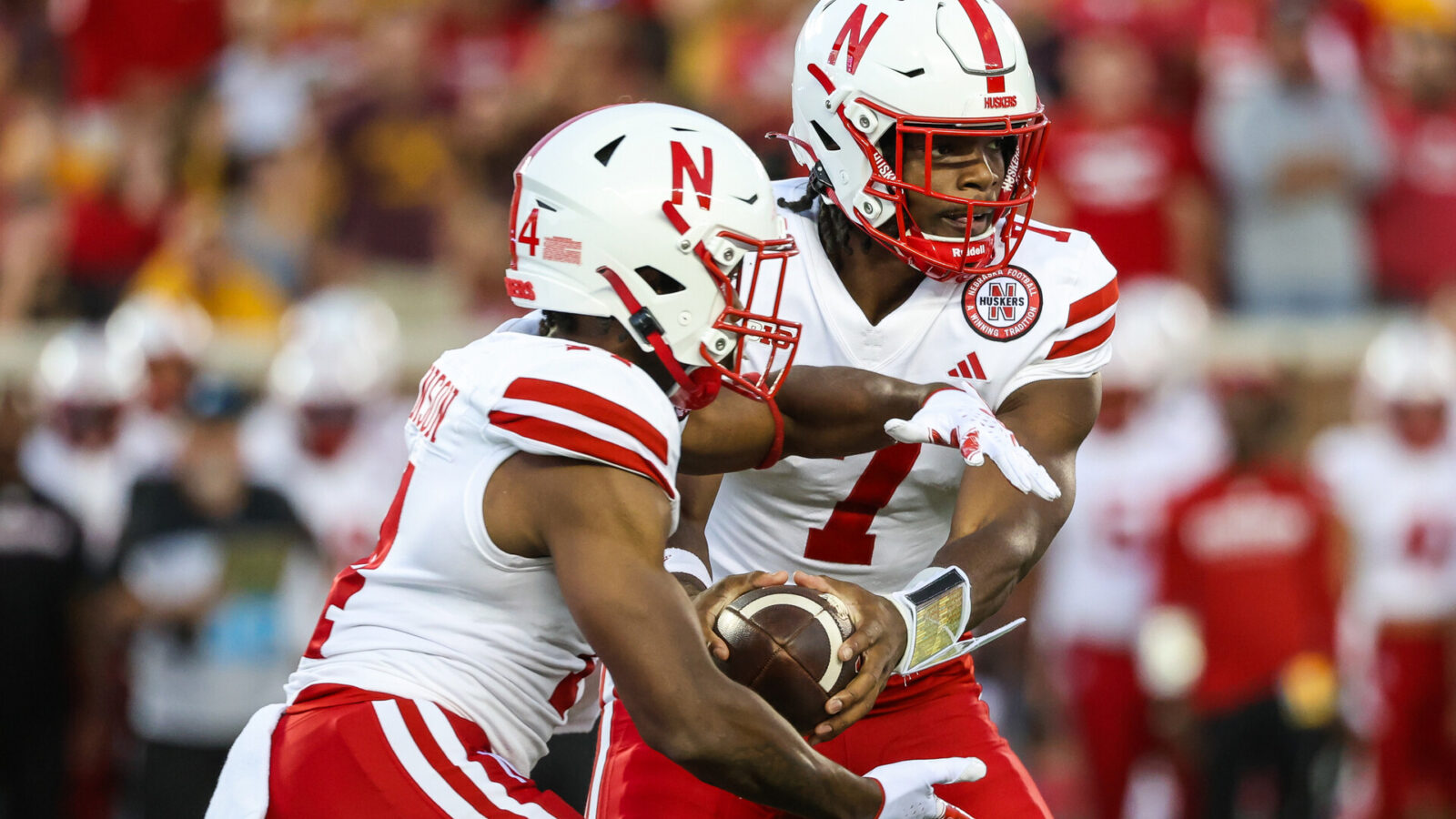 Nebraska Cornhuskers quarterback Jeff Sims (7) hands the ball off to running back Rahmir Johnson (14) during the second quarter against the Minnesota Golden Gophers at Huntington Bank Stadium.