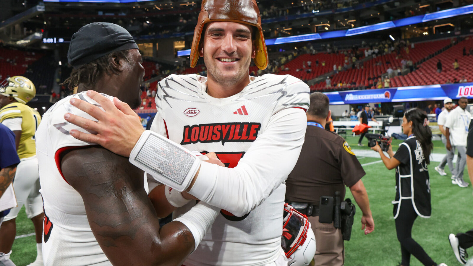Louisville Cardinals defensive back Gilbert Frierson (13) and quarterback Jack Plummer (13) celebrate after a victory against the Georgia Tech Yellow Jackets at Mercedes-Benz Stadium.