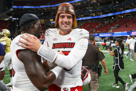 Louisville Cardinals defensive back Gilbert Frierson (13) and quarterback Jack Plummer (13) celebrate after a victory against the Georgia Tech Yellow Jackets at Mercedes-Benz Stadium.
