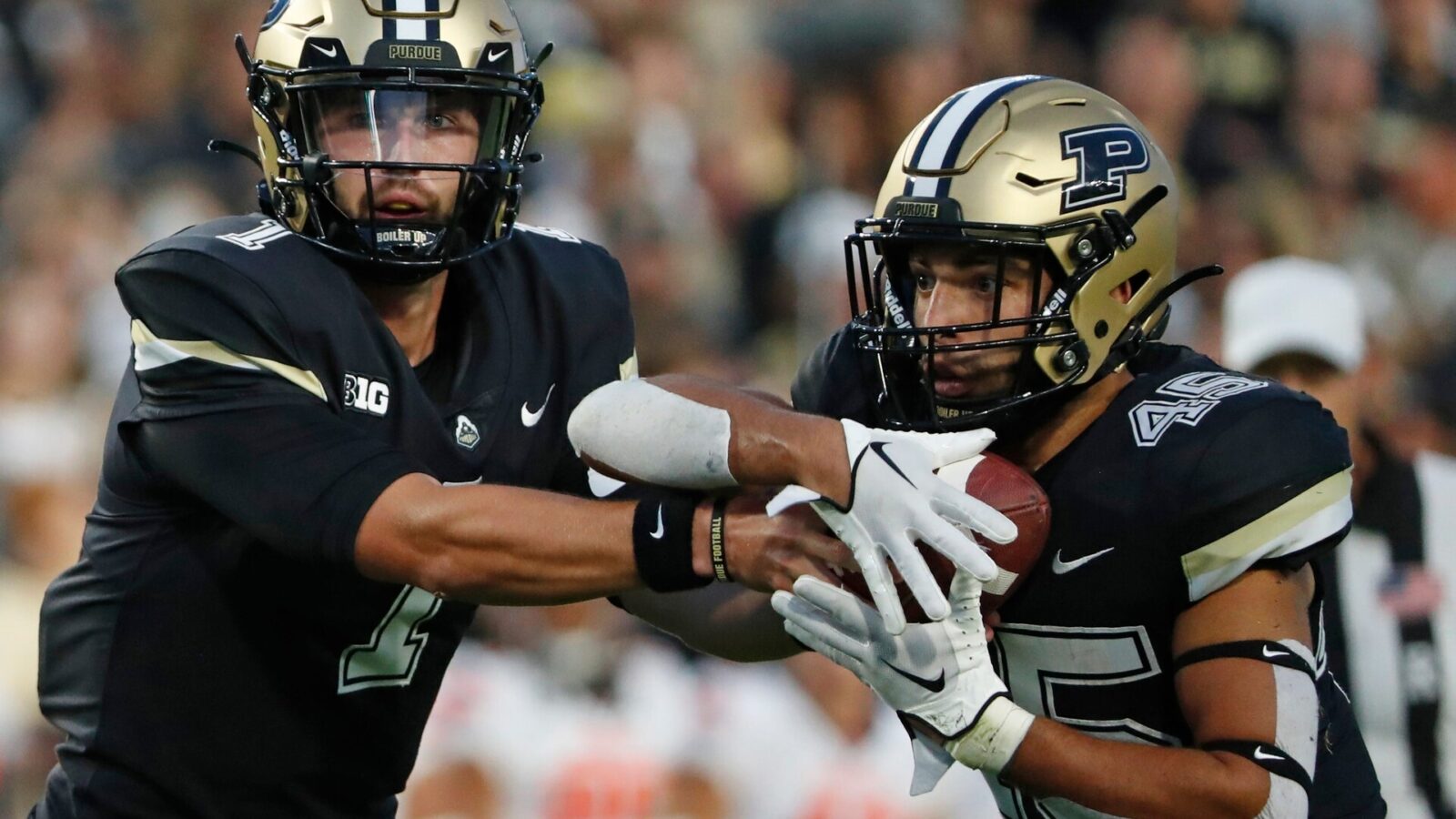Purdue Boilermakers quarterback Hudson Card (1) hands the ball off to Purdue Boilermakers running back Devin Mockobee (45) during the NCAA football game against the Syracuse Orange, Wednesday, July 12, 2023, at Ross-Ade Stadium in West Lafayette, Ind.