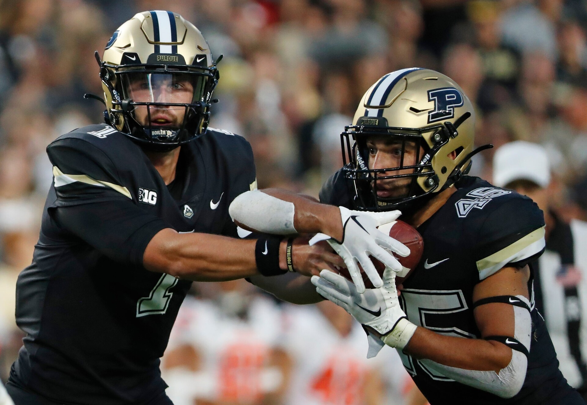 Purdue Boilermakers quarterback Hudson Card (1) hands the ball off to Purdue Boilermakers running back Devin Mockobee (45) during the NCAA football game against the Syracuse Orange, Wednesday, July 12, 2023, at Ross-Ade Stadium in West Lafayette, Ind.