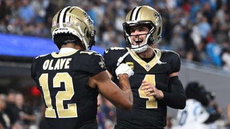 New Orleans Saints quarterback Derek Carr (4) reacts with wide receiver Chris Olave (12) in the fourth quarter at Bank of America Stadium.