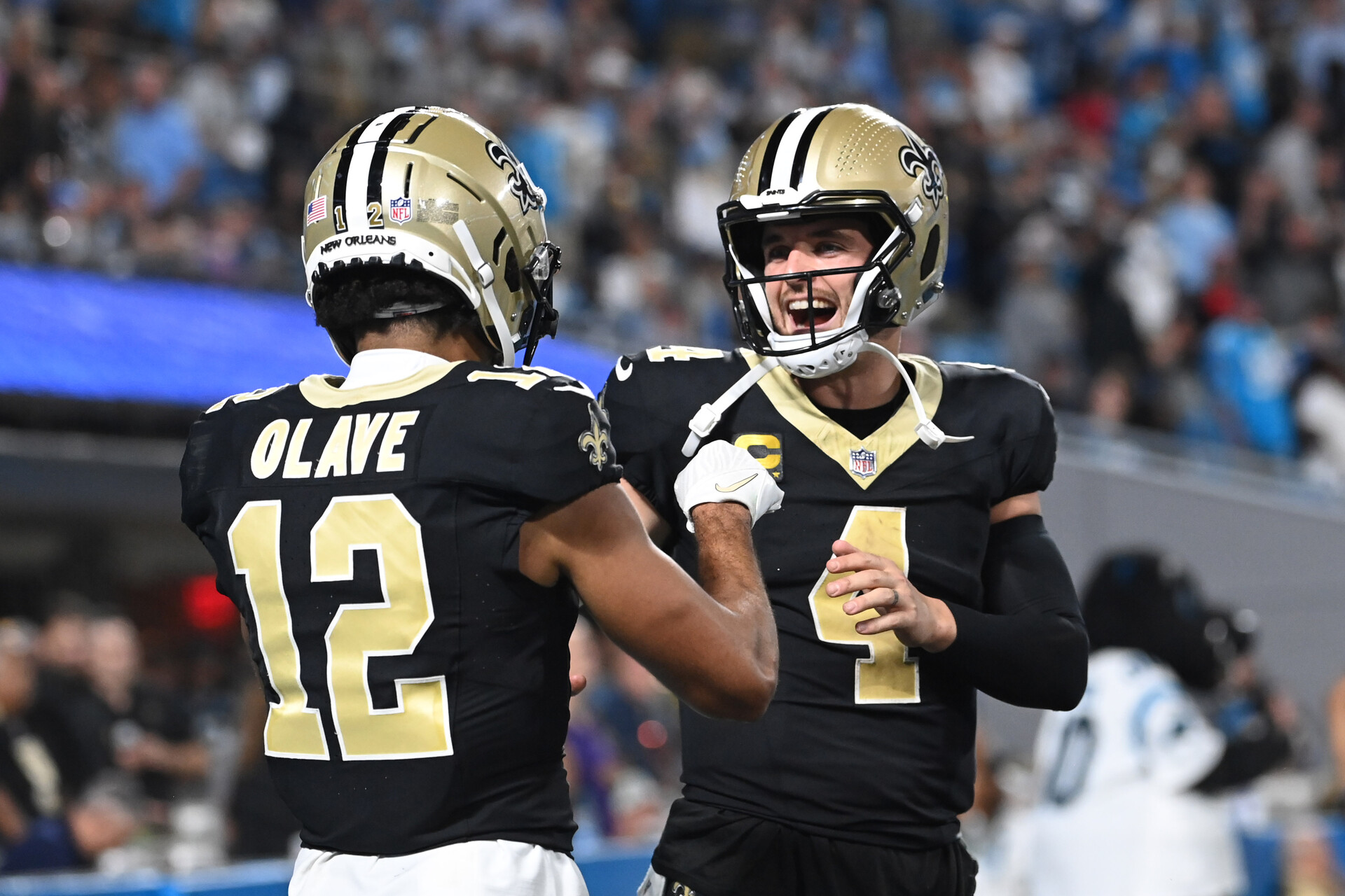 New Orleans Saints quarterback Derek Carr (4) reacts with wide receiver Chris Olave (12) in the fourth quarter at Bank of America Stadium.