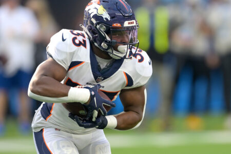 Denver Broncos running back Javonte Williams (33) carries the ball for a short gain in the first half against the Los Angeles Chargers at SoFi Stadium.