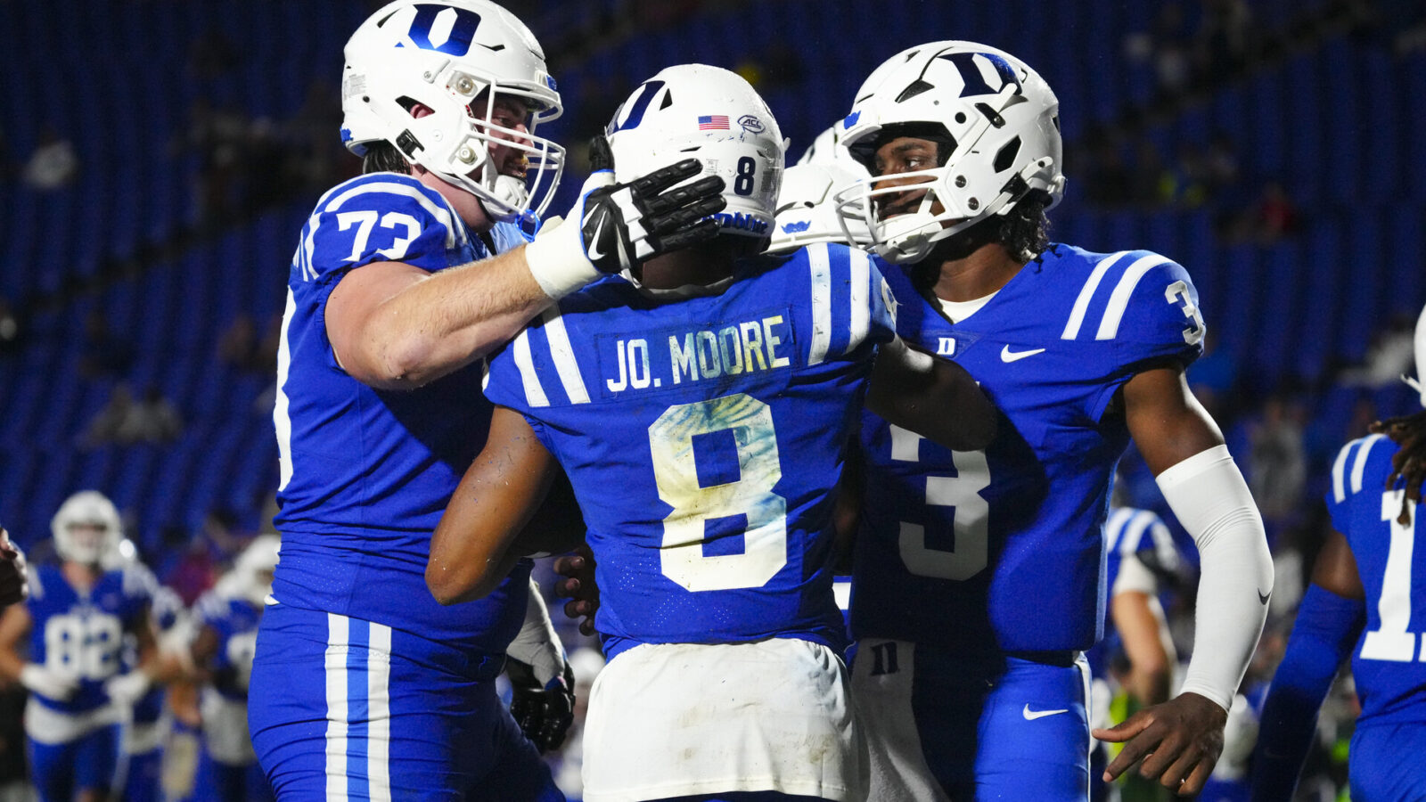 Duke Blue Devils wide receiver Jordan Moore (8) is congratulated by offensive lineman Jake Hornibrook (73) and quarterback Henry Belin IV (3) after his touchdown run against the Lafayette Leopards Duke Blue Devils punter during the second half at Wallace Wade Stadium.